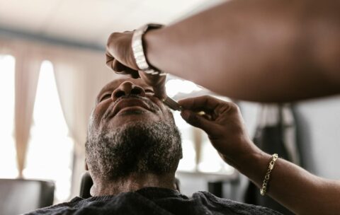 A serene moment during a beard trim in a barbershop, featuring skilled hands and focused attention.
