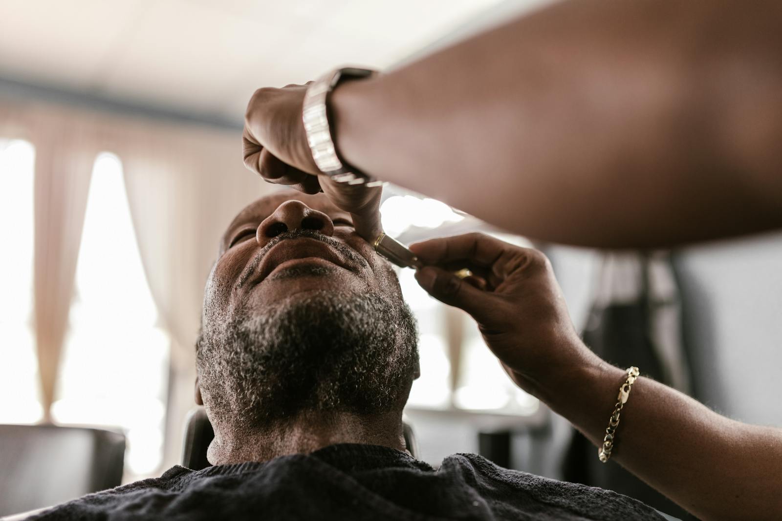 A serene moment during a beard trim in a barbershop, featuring skilled hands and focused attention.