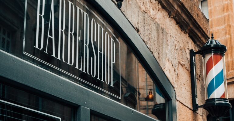 a barber shop sign on the side of a building