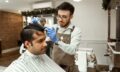 man in white dress shirt cutting hair of man in white dress shirt