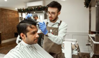 man in white dress shirt cutting hair of man in white dress shirt
