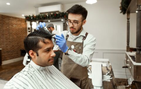 man in white dress shirt cutting hair of man in white dress shirt